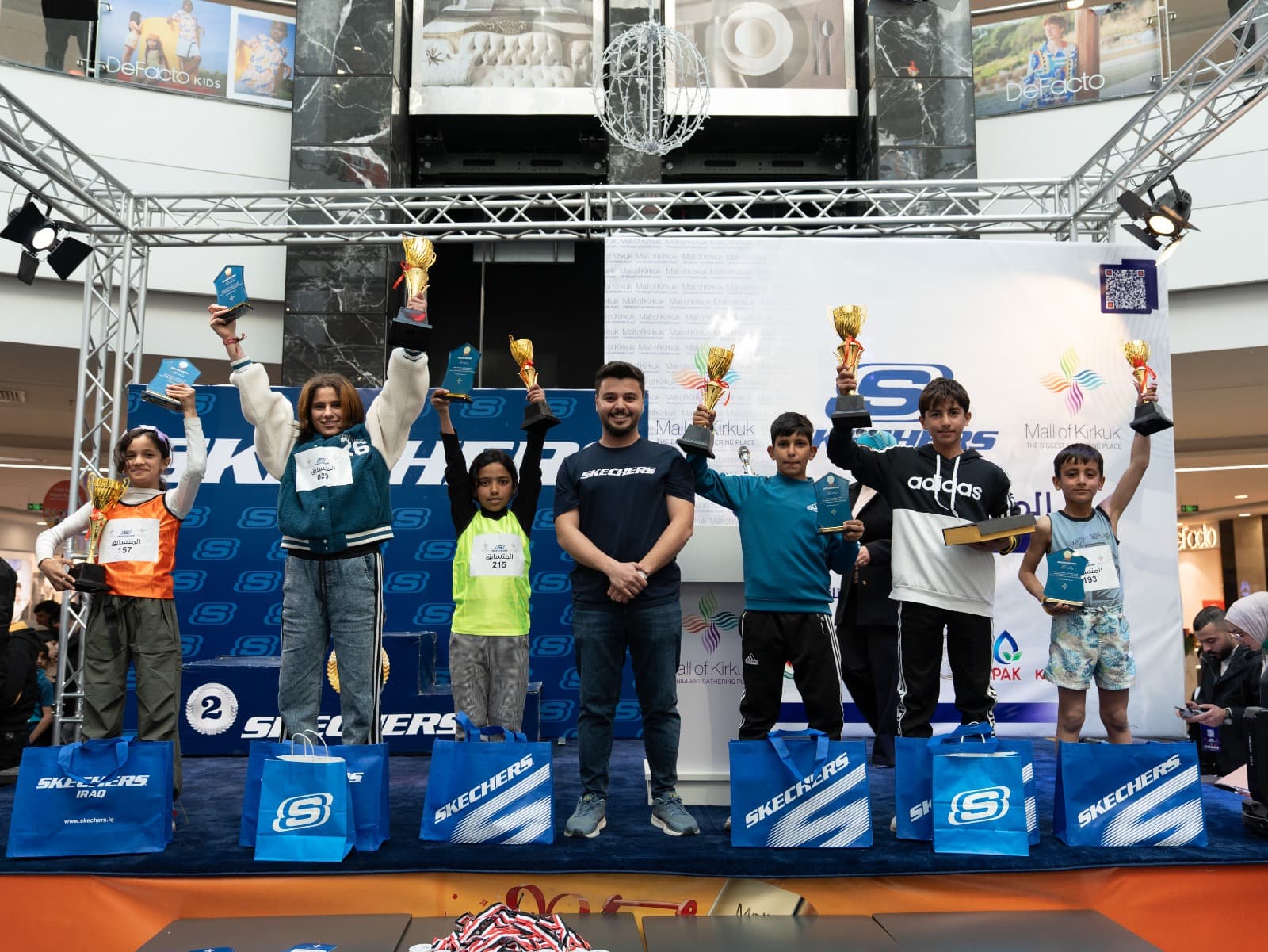 Young athletes with trophies at a Skechers mall event